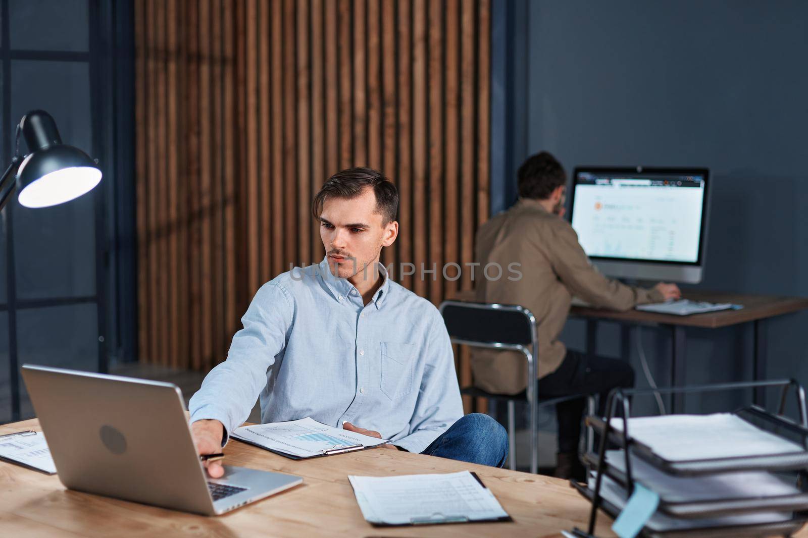 thoughtful businessman sitting at his desk late at night. concept of overtime work.