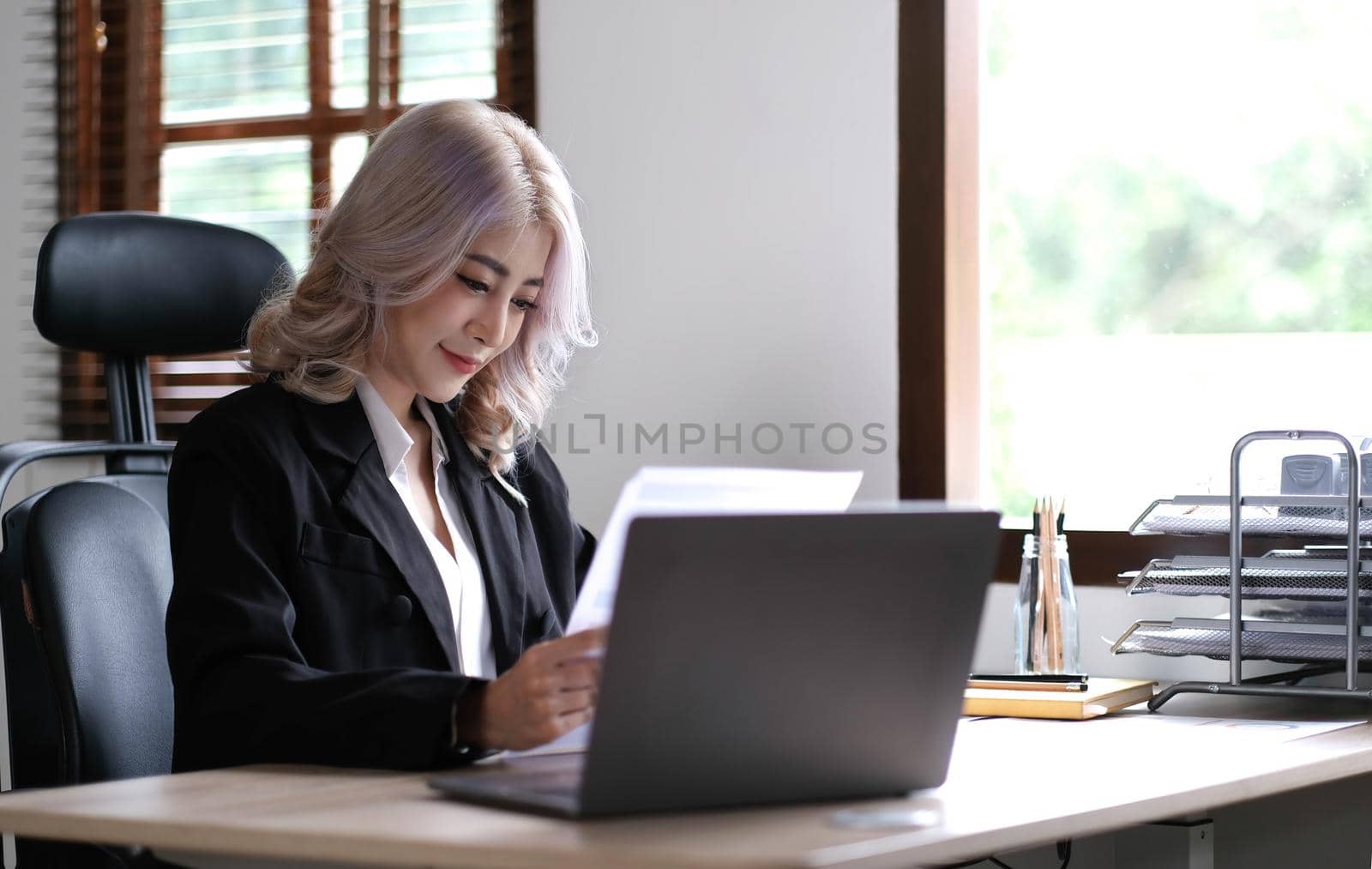 Smiling asian business woman sitting in a modern office..