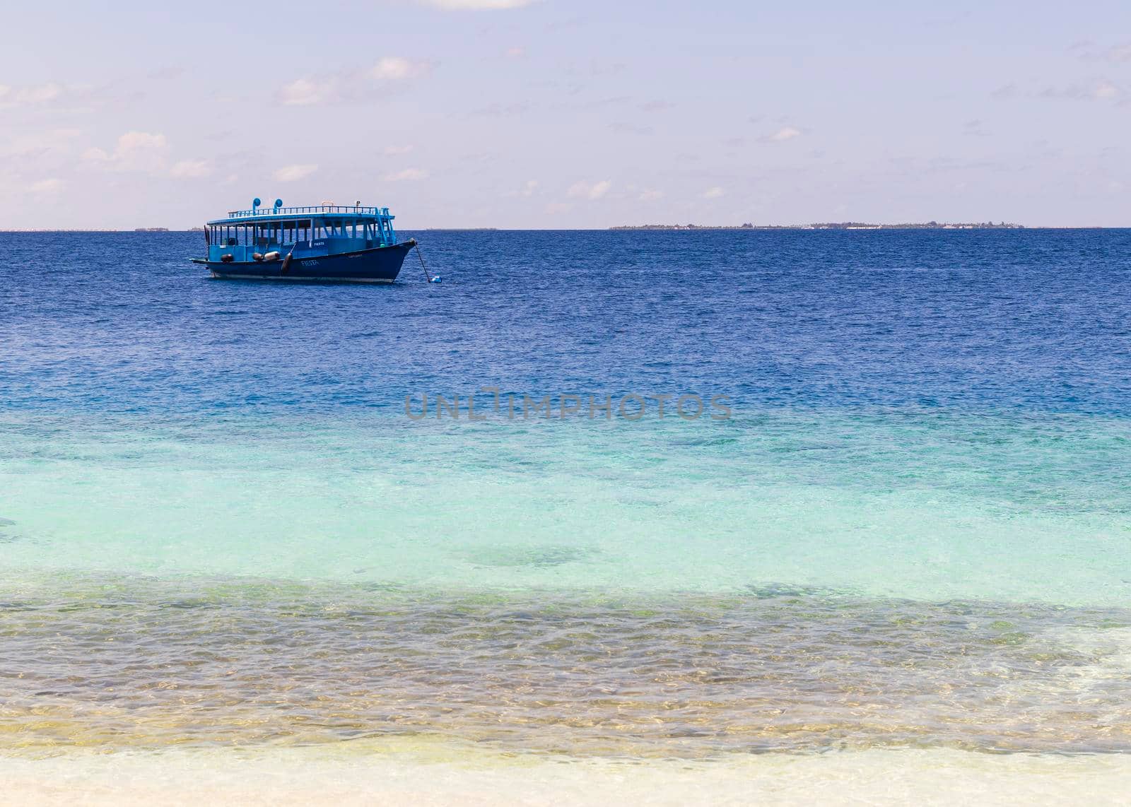 Blue painted boat anchored close to shore.