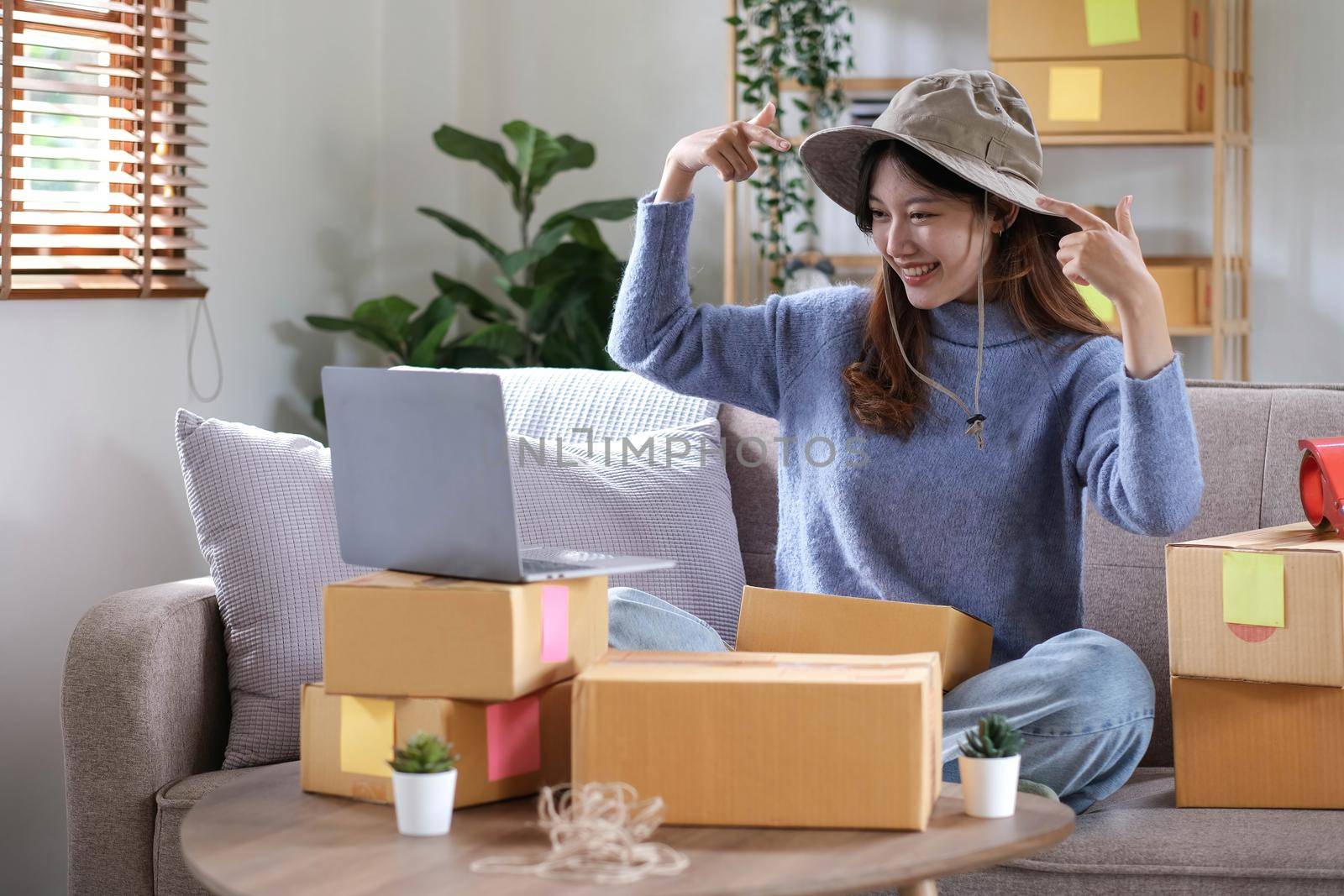Startup small business entrepreneur SME, asian woman packing cloth in box. Portrait young Asian small business owner home office, online sell marketing delivery, SME e-commerce telemarketing concept.