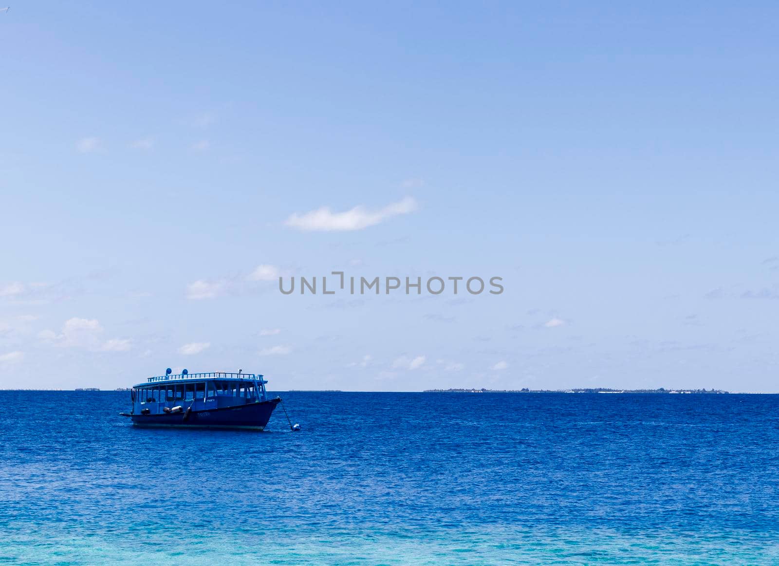 Blue painted boat anchored close to shore.