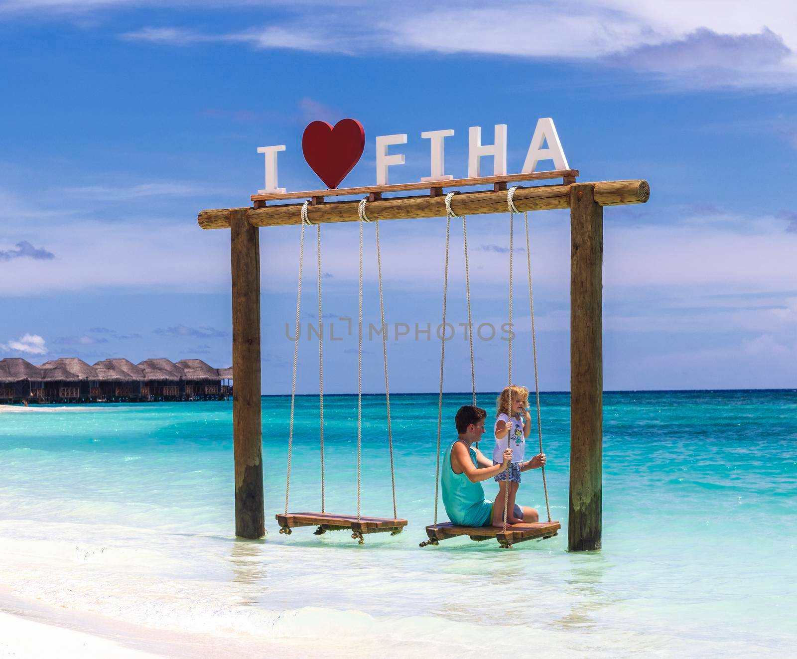 Male, Maldives 04.24.2021 - Kids are playing on the swing at Fihalhohi island resort beach. holiday by pazemin