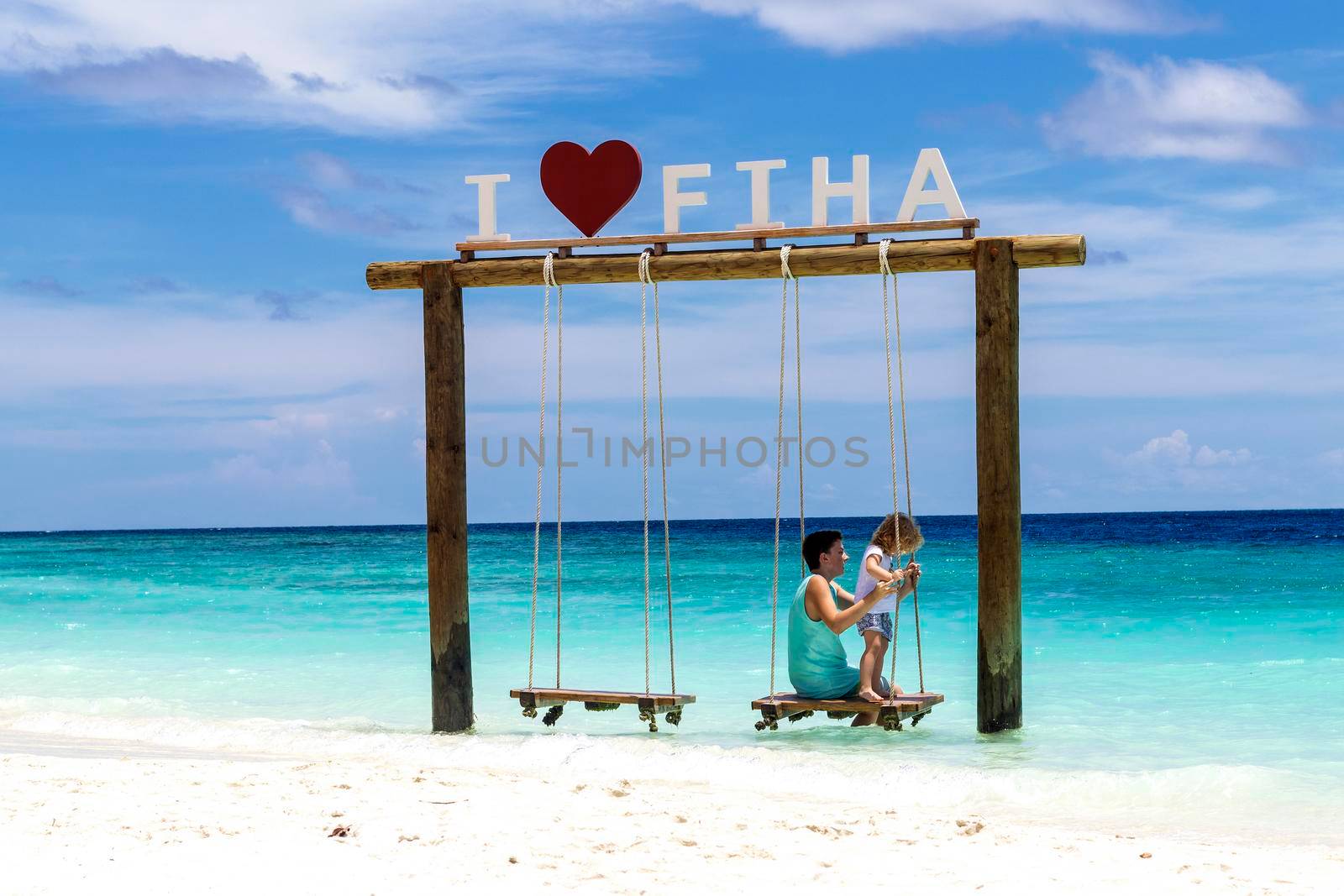 Male, Maldives 04.24.2021 - Kids are playing on the swing at Fihalhohi island resort beach. holiday by pazemin