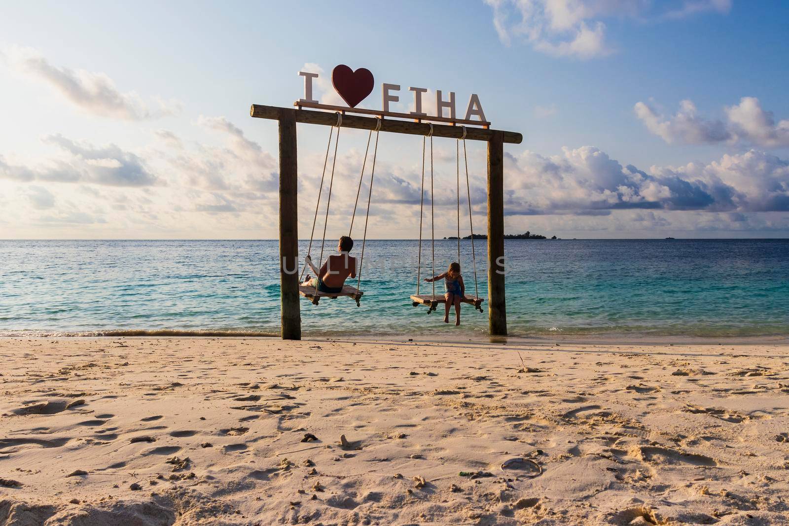 Male, Maldives 04.24.2021 - Kids are playing on the swing at Fihalhohi island resort beach. holiday by pazemin