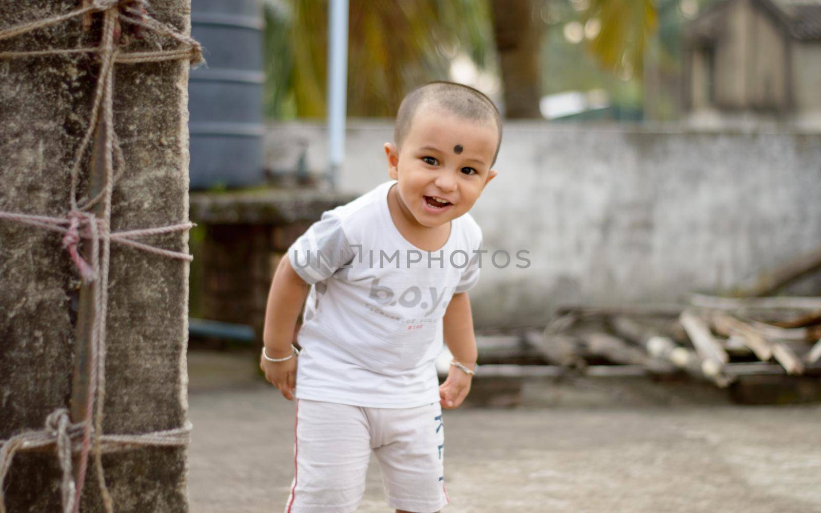 Cute smart naughty baby making a funny and looking at camera. Happy baby background.