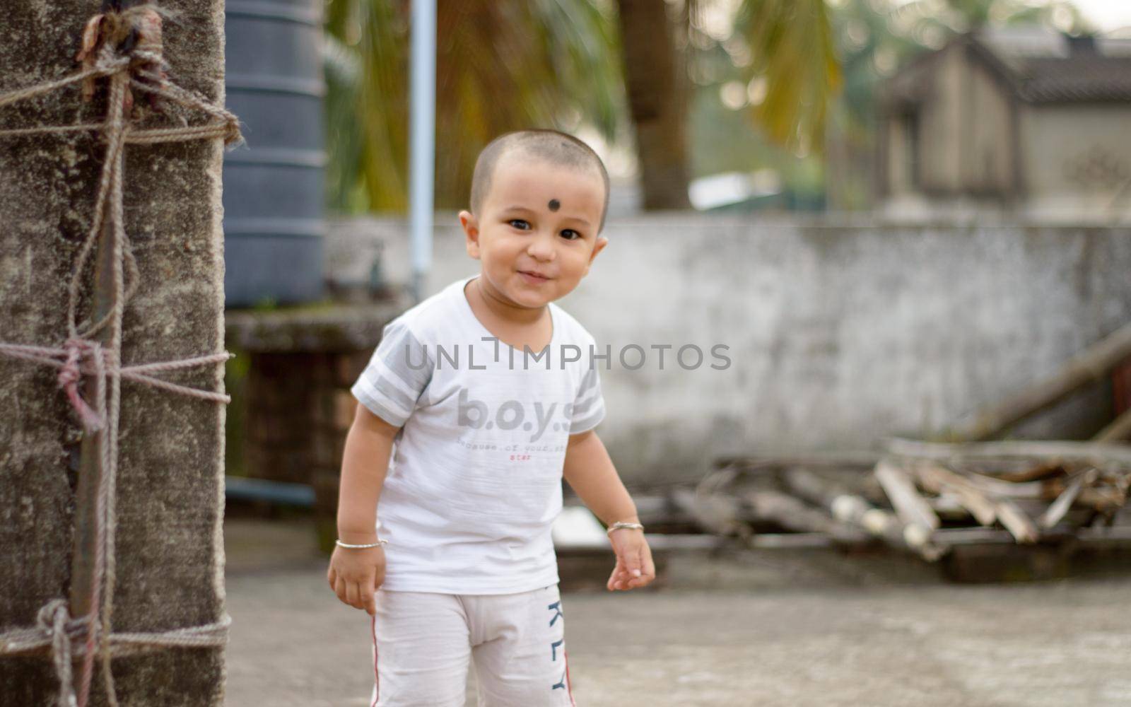 Cute smart naughty baby making a funny and looking at camera. Happy baby background. by sudiptabhowmick