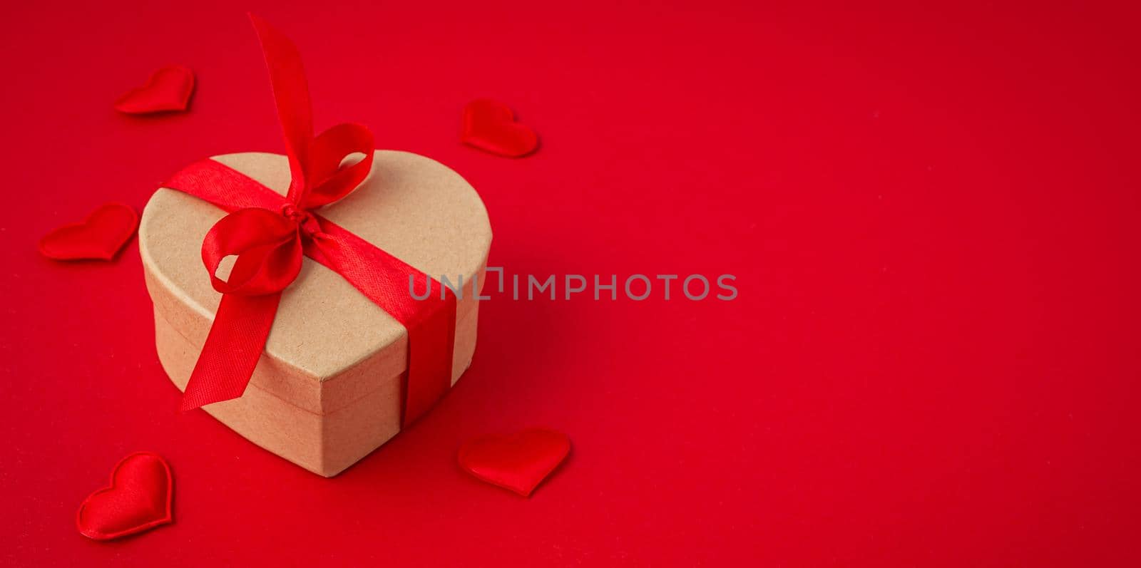 Gift boxe in heart shape with bow on red background, Saint Valentine Day by its_al_dente