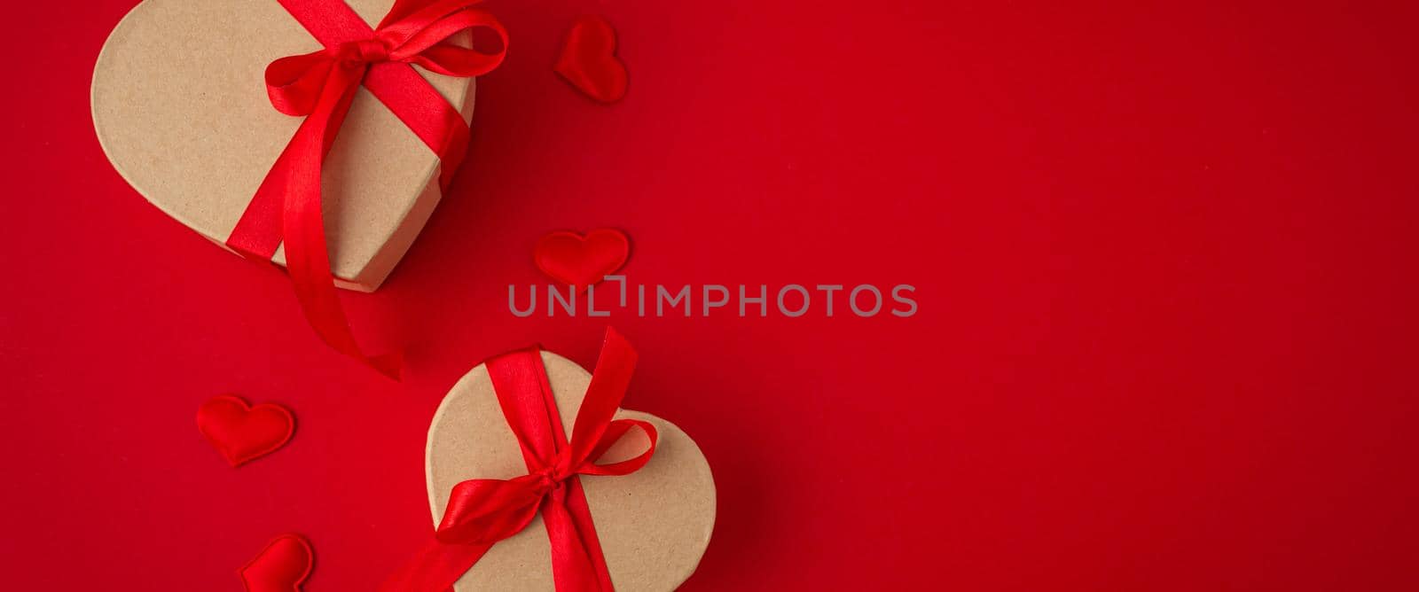 Two wrapped gift boxes in heart shape on red background, Saint Valentine Day by its_al_dente