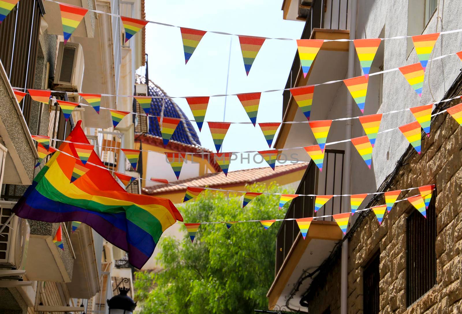 Streets and facades adorned with colorful rainbow flags for The Gay Pride in Benidorm