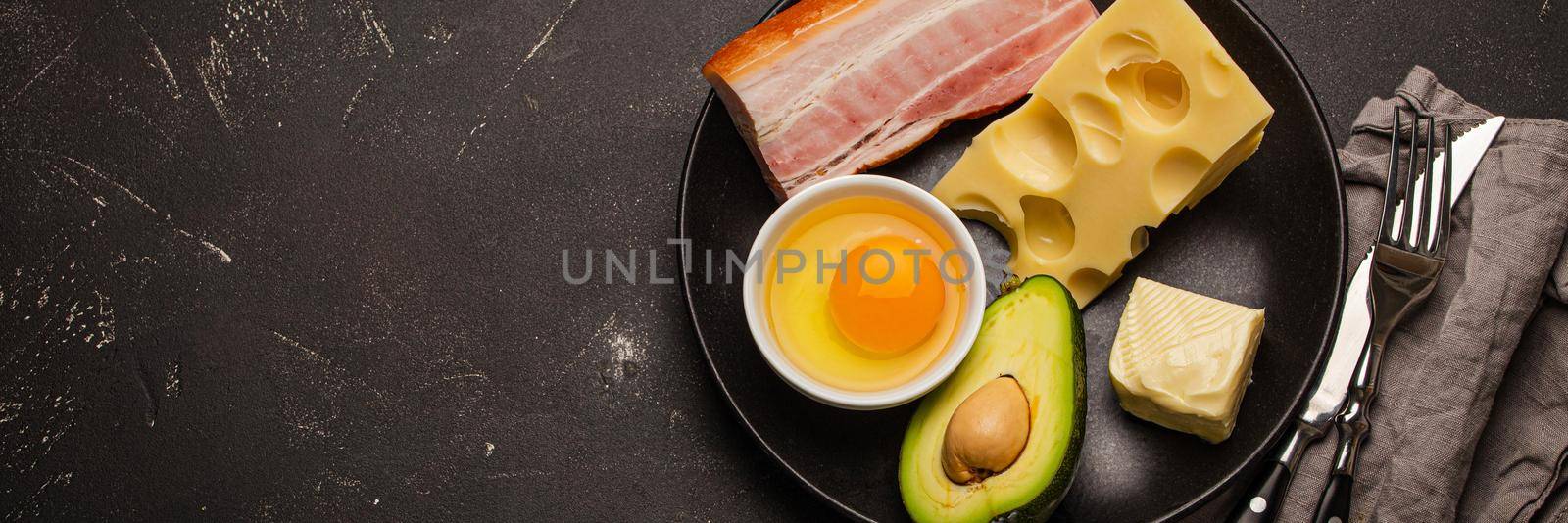 Foods for keto diet on black plate on dark background copy space by its_al_dente