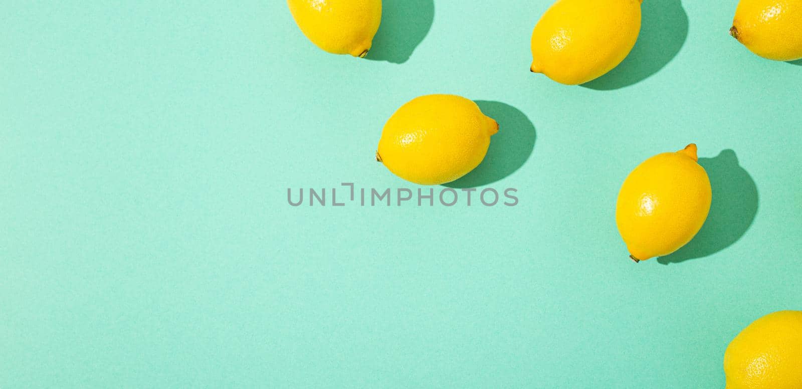 yellow whole lemons on minimal blue background on bright sun light with hard shadows pattern by its_al_dente