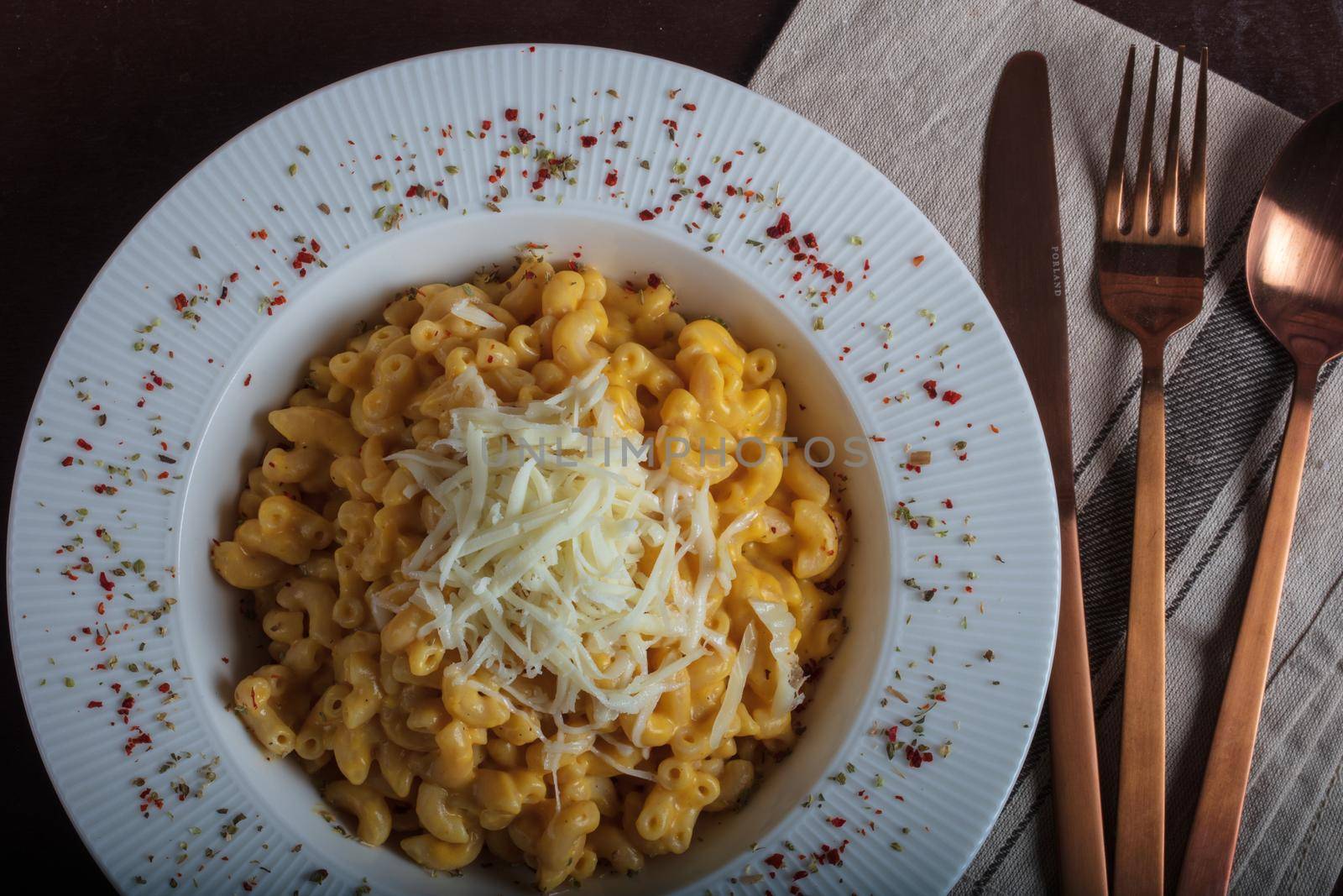 Mac and cheese, american style macaroni pasta with cheesy sauce on dark rustic table, top view. High quality photo