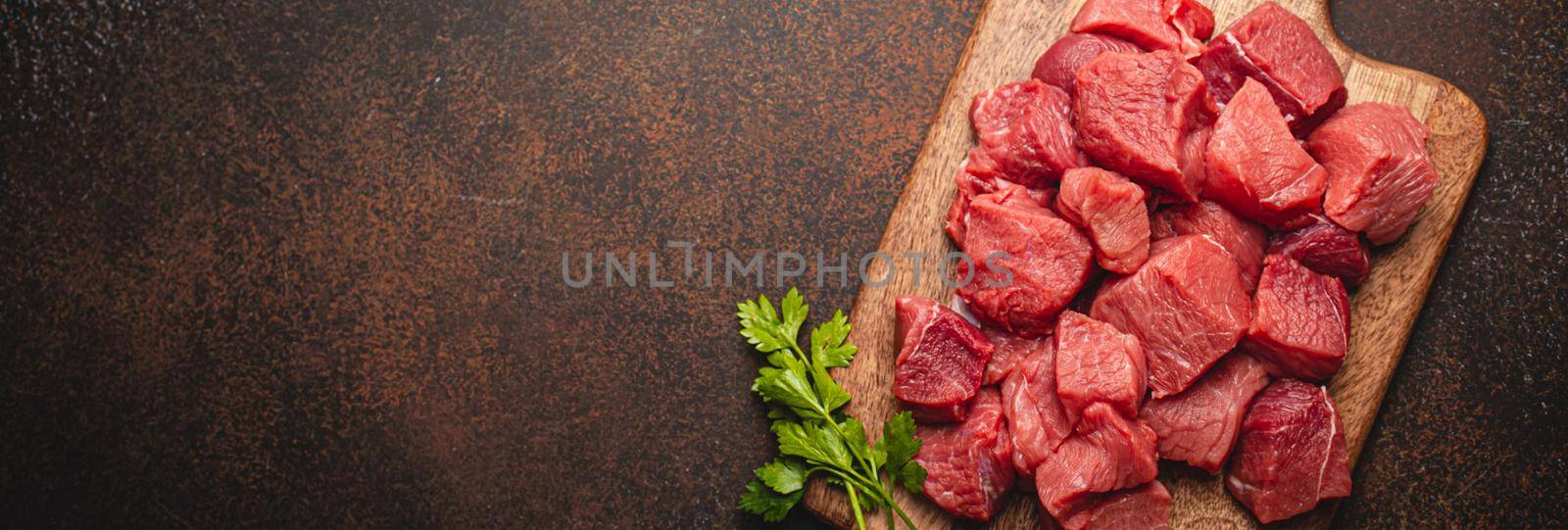 Beef raw meat cubes for stew on wooden cutting board copy space by its_al_dente