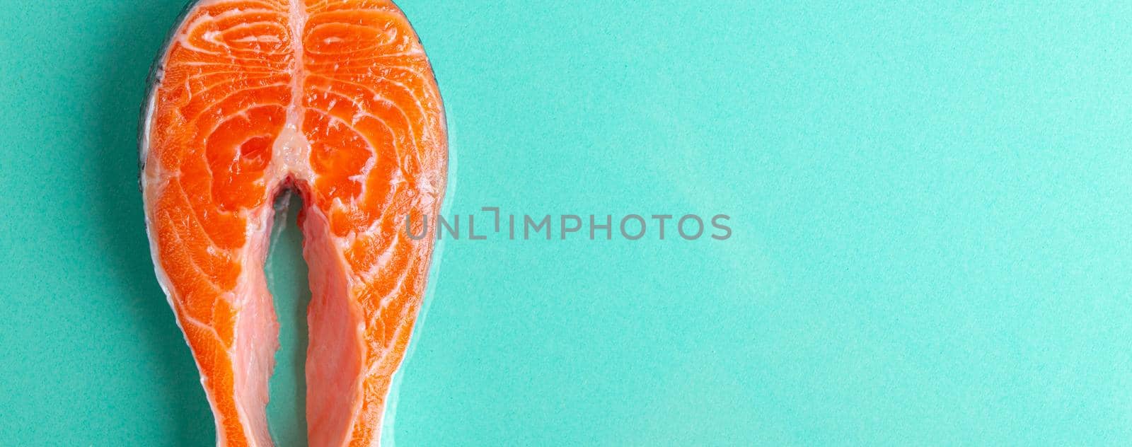 Uncooked raw fresh fish salmon steak top view on blue clean background from above, delicacy healthy fish eating and nutrition concept flat lay space for text