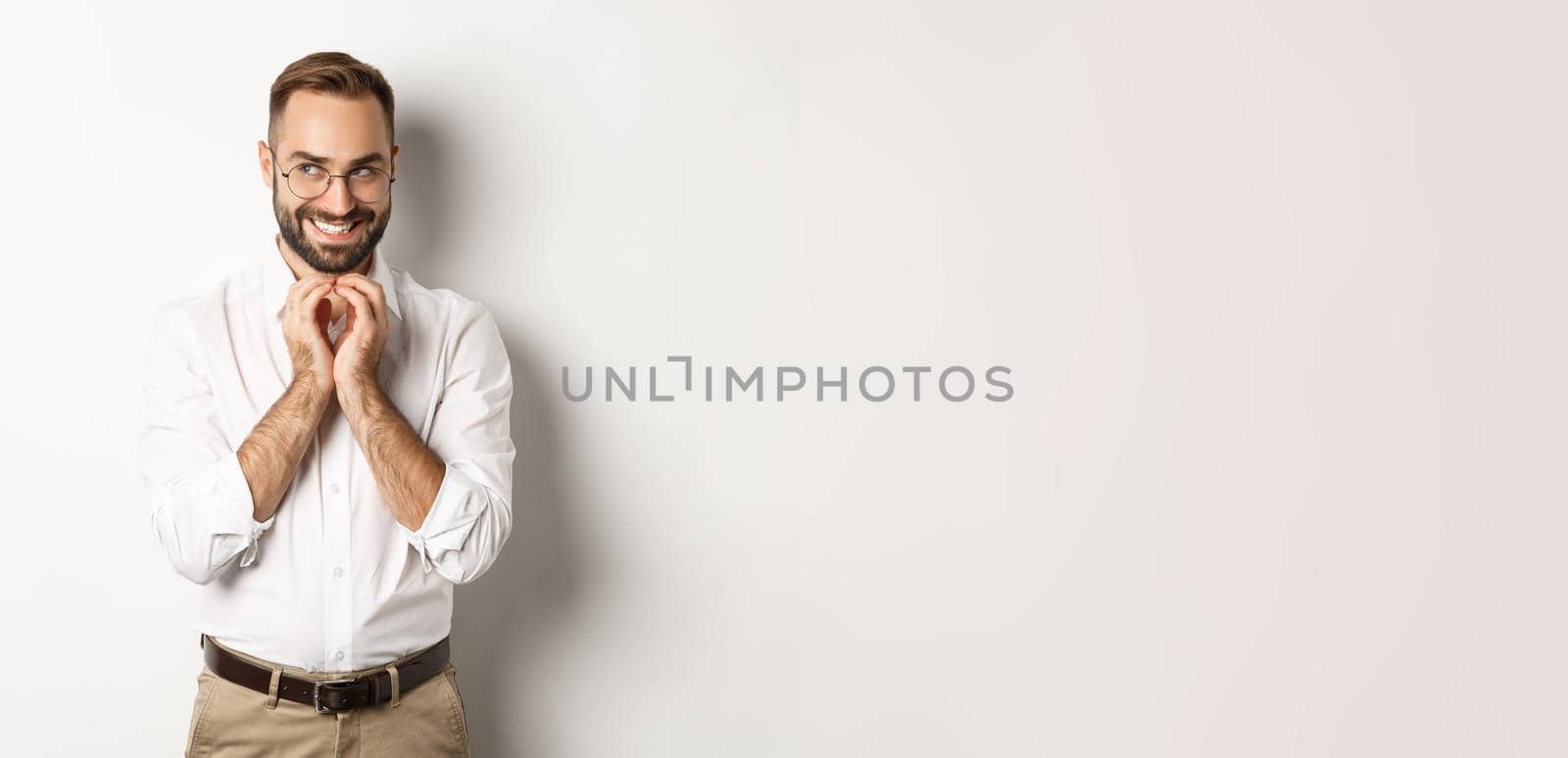 Young cunning businessman steeple fingers and smiling devious, scheming plan, standing over white background by Benzoix