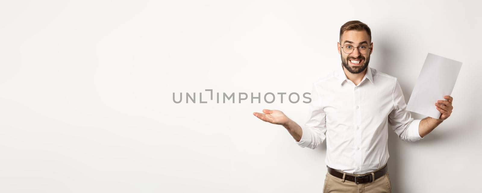 Awkward manager showing document and shrugging, looking guilty of mistake, standing over white background.