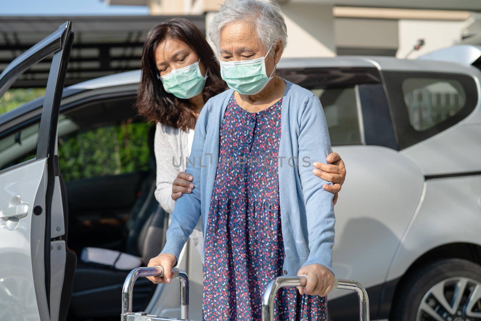 Caregiver help and support asian senior or elderly old lady woman patient walk with walker prepare get to her car, healthy strong medical concept. by pamai