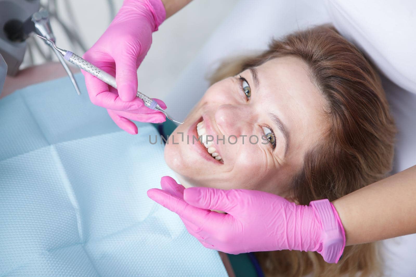 Close up of a happy mature woman smiling to the camera during dental appointment at the clinic