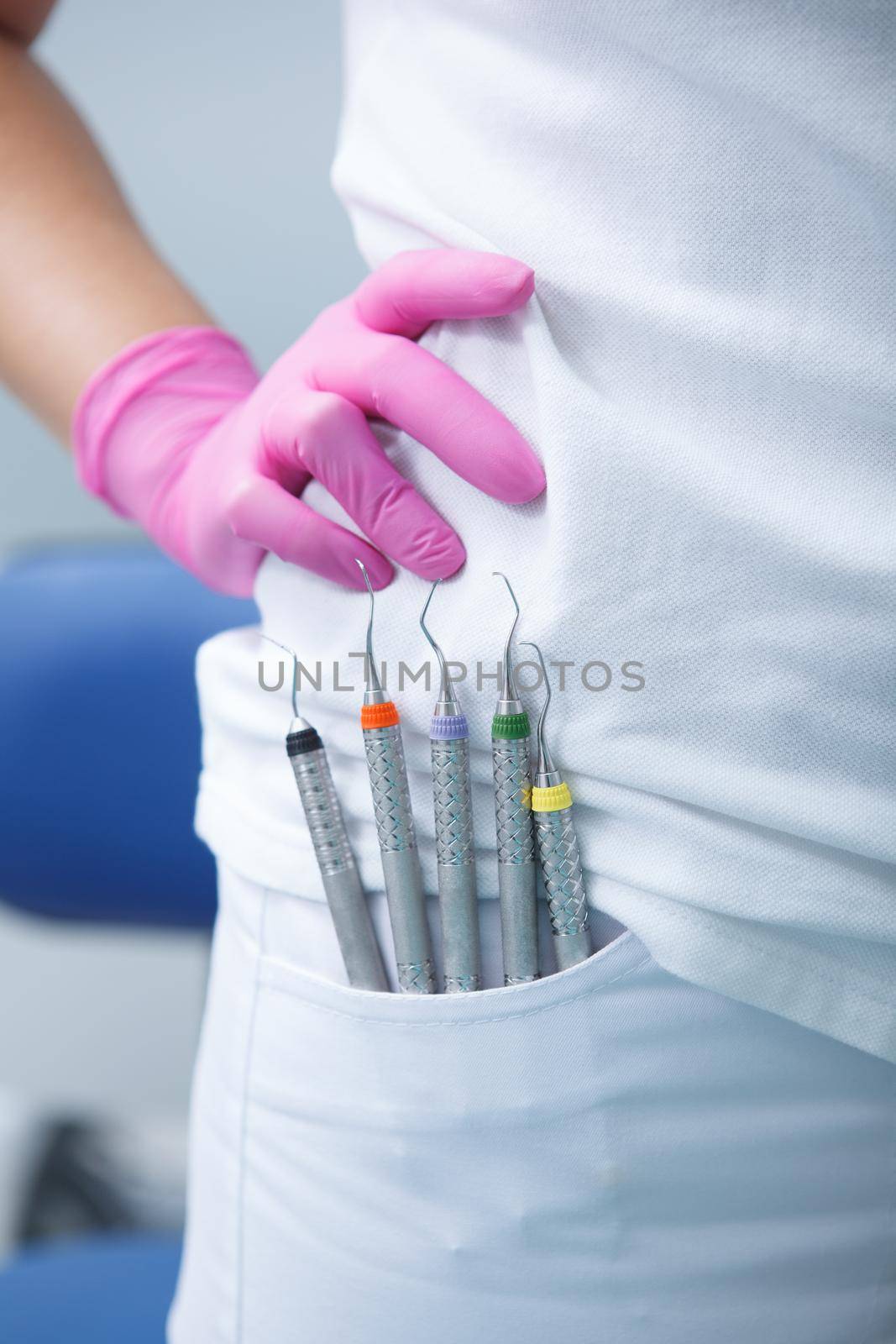 Vertical close up of dental tools in the pocket of unrecognizable dentist