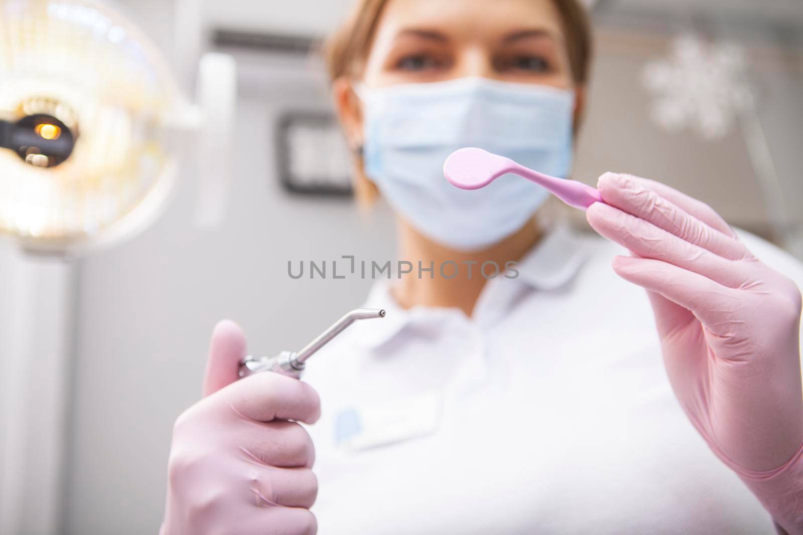 Female professional dentist working at dental clinic by MAD_Production