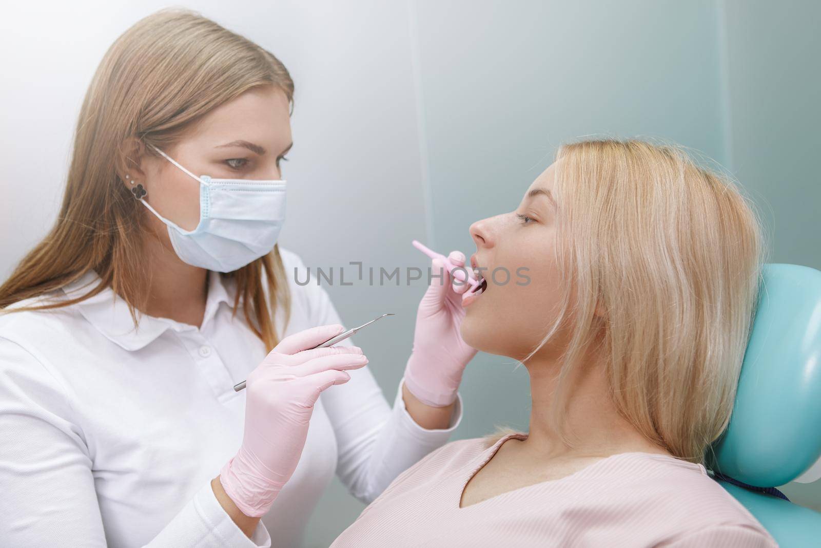 Female patient getting teeth examined by professional dentist
