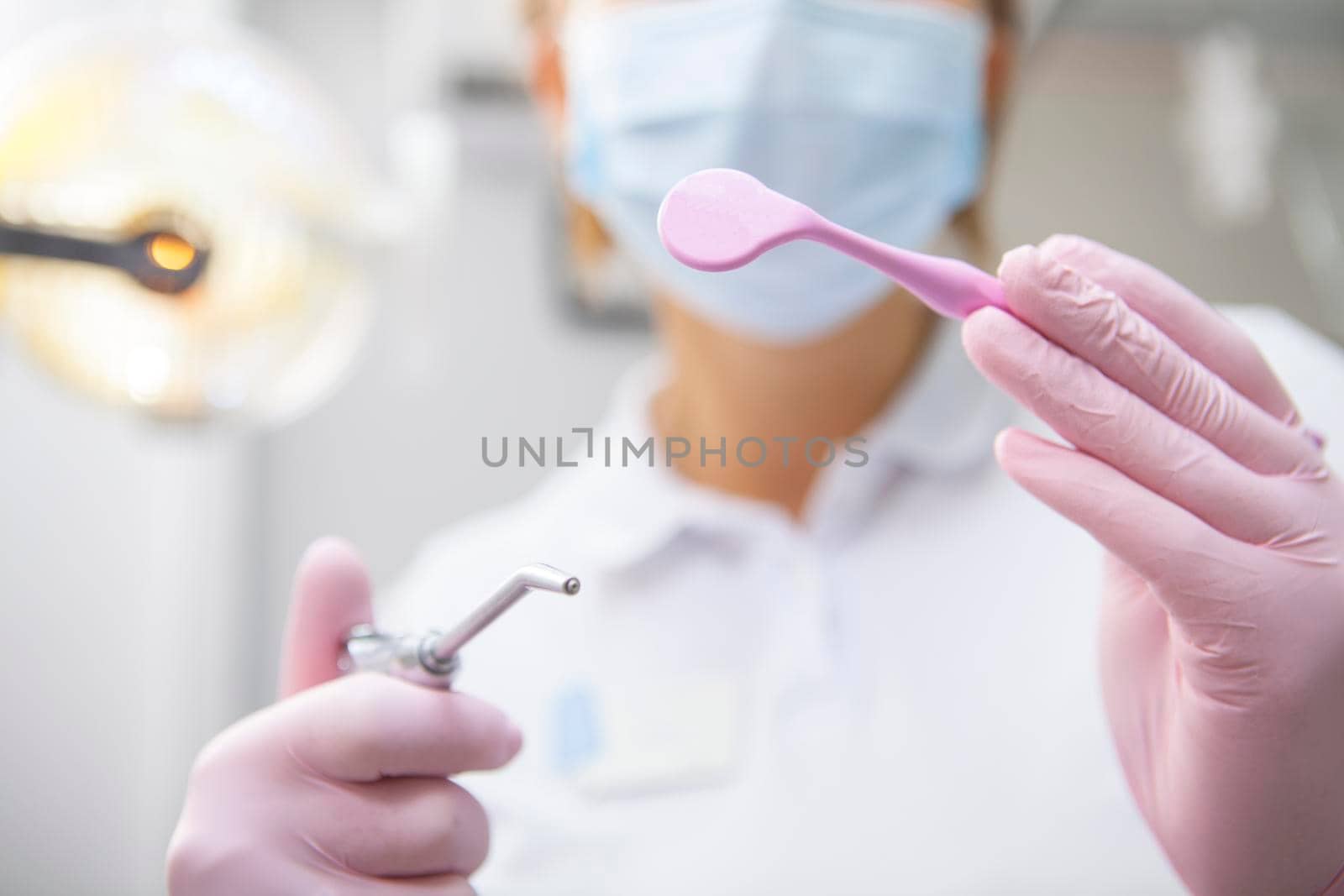 Cropped close up of professional dentist wearing medical mask, holding dental tools