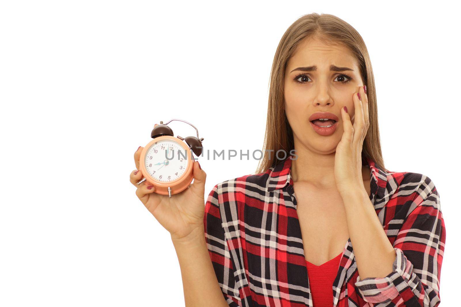 Stressed woman holding alarm clock by MAD_Production