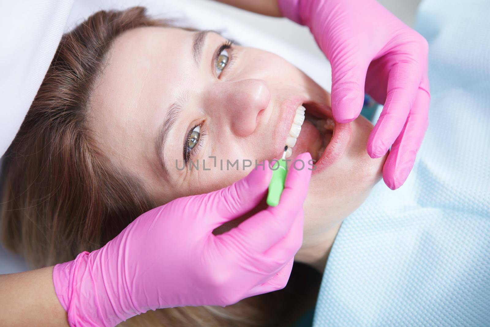 Close up of a woman having professional dental cleaning at the clinic, dentist using interdental brushes