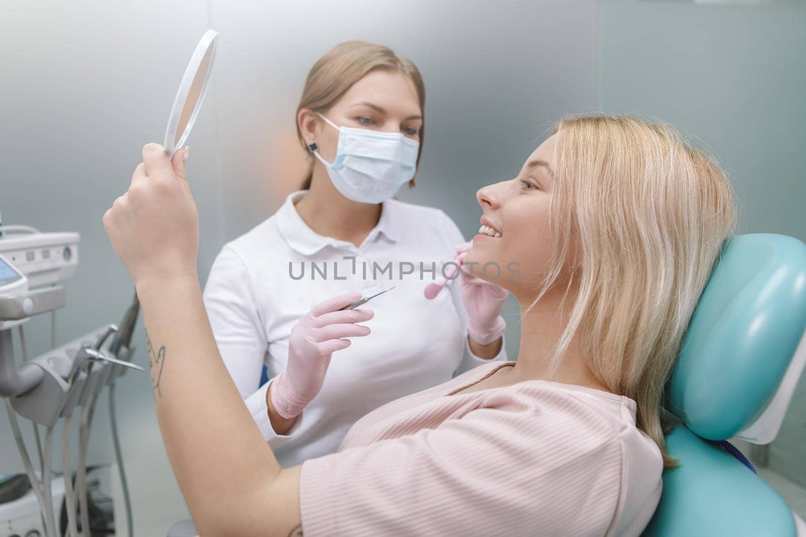 Happy woman smiling looking in the mirror after dental checkup