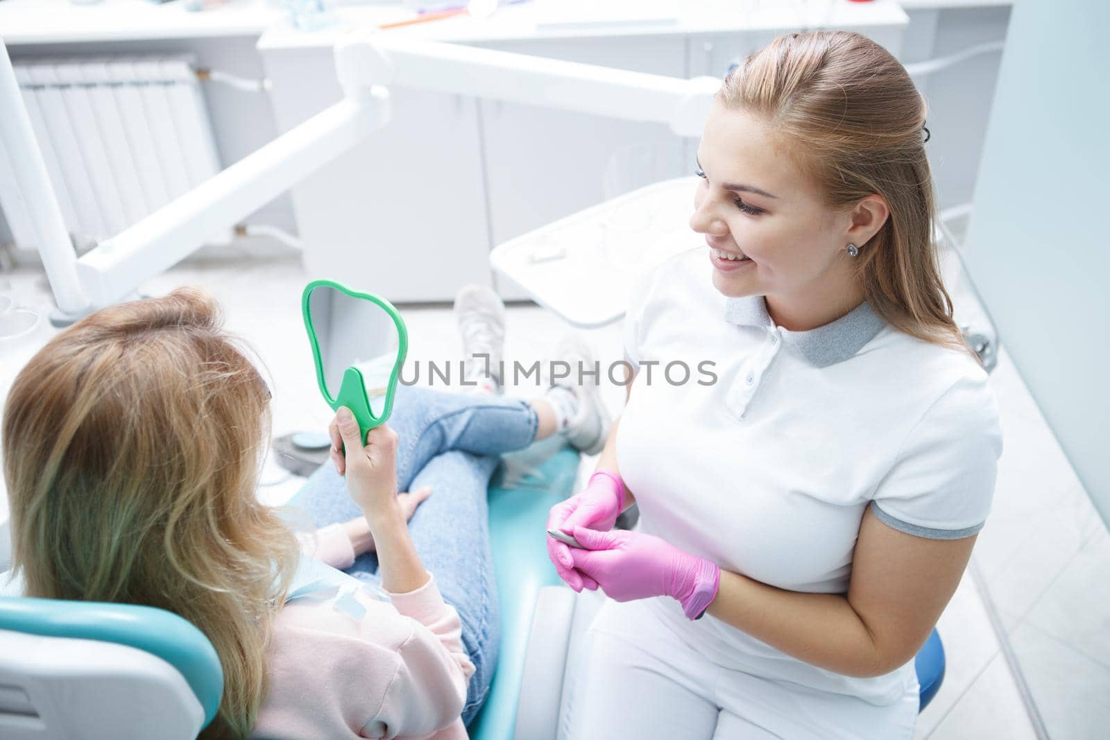Top view shot of a charming young female dentist talking to her patient after dental checkup
