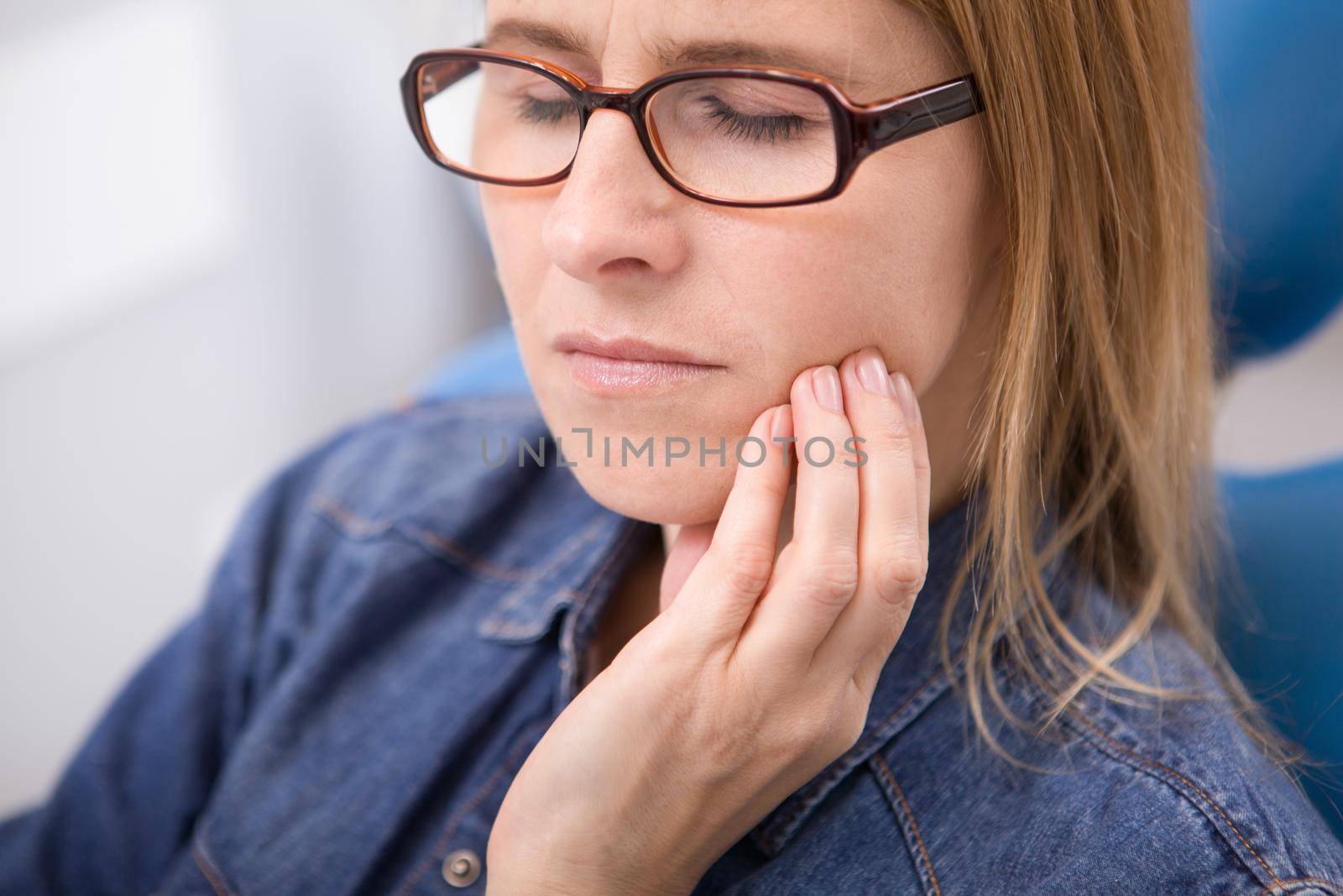 Mature woman suffering from toothache by MAD_Production