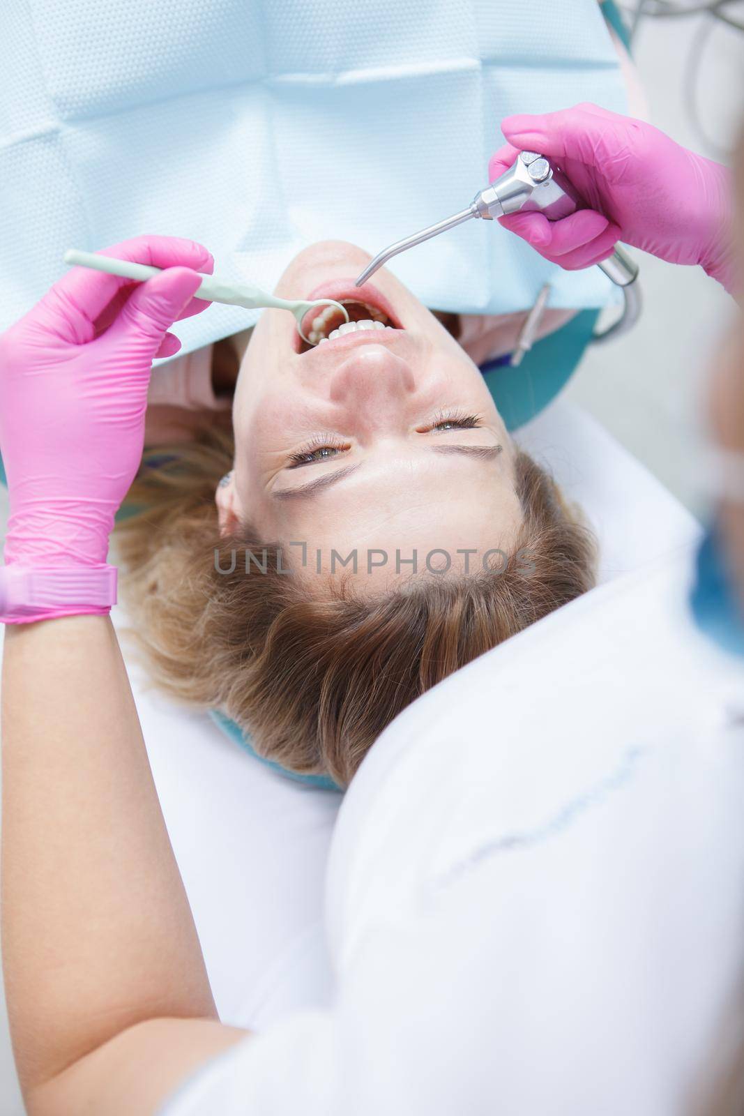 Vertical top view shot of a mature woman getting dental treatment by professional dentist