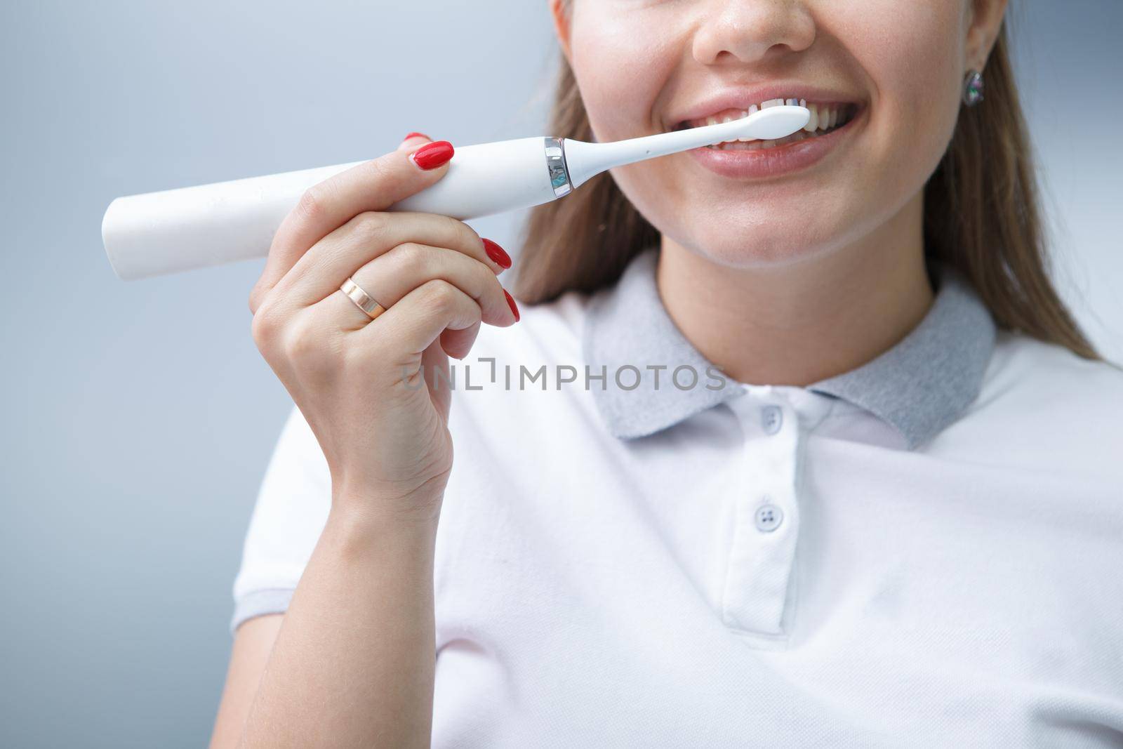 Cropped shot of a female dentist showing using electric toothbrush