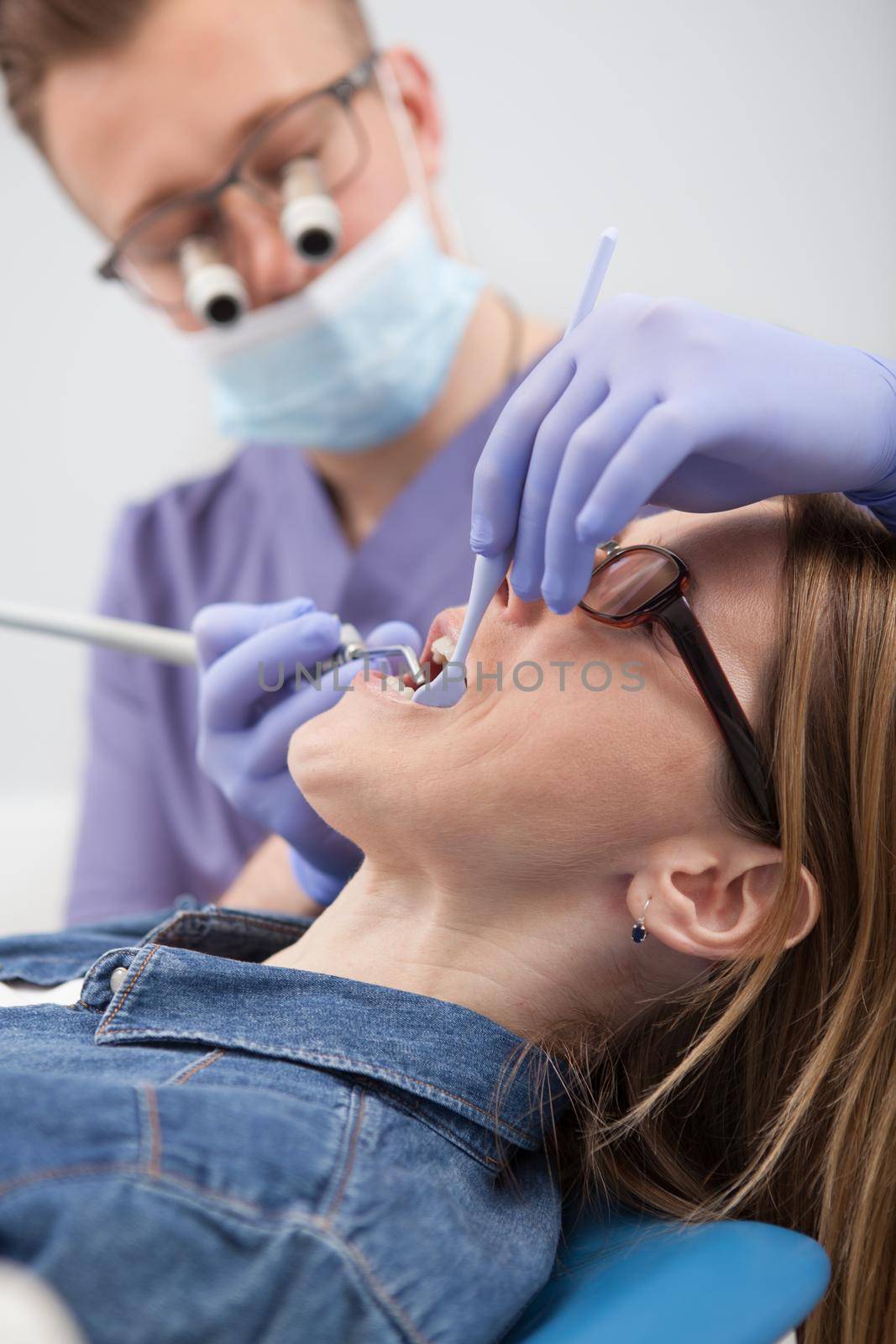 Professional dentist having appointment with patient by MAD_Production