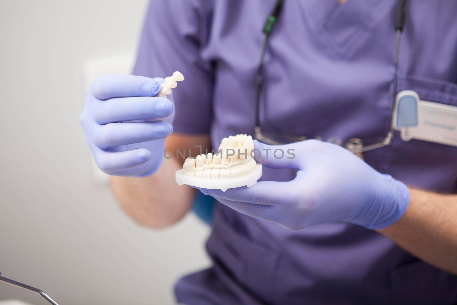 Unrecognizable dentist holding dental mold
