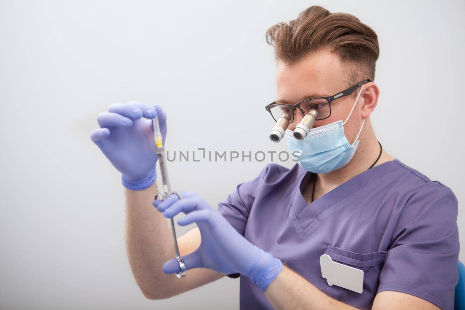 Doctor preparing syringe for injection by MAD_Production