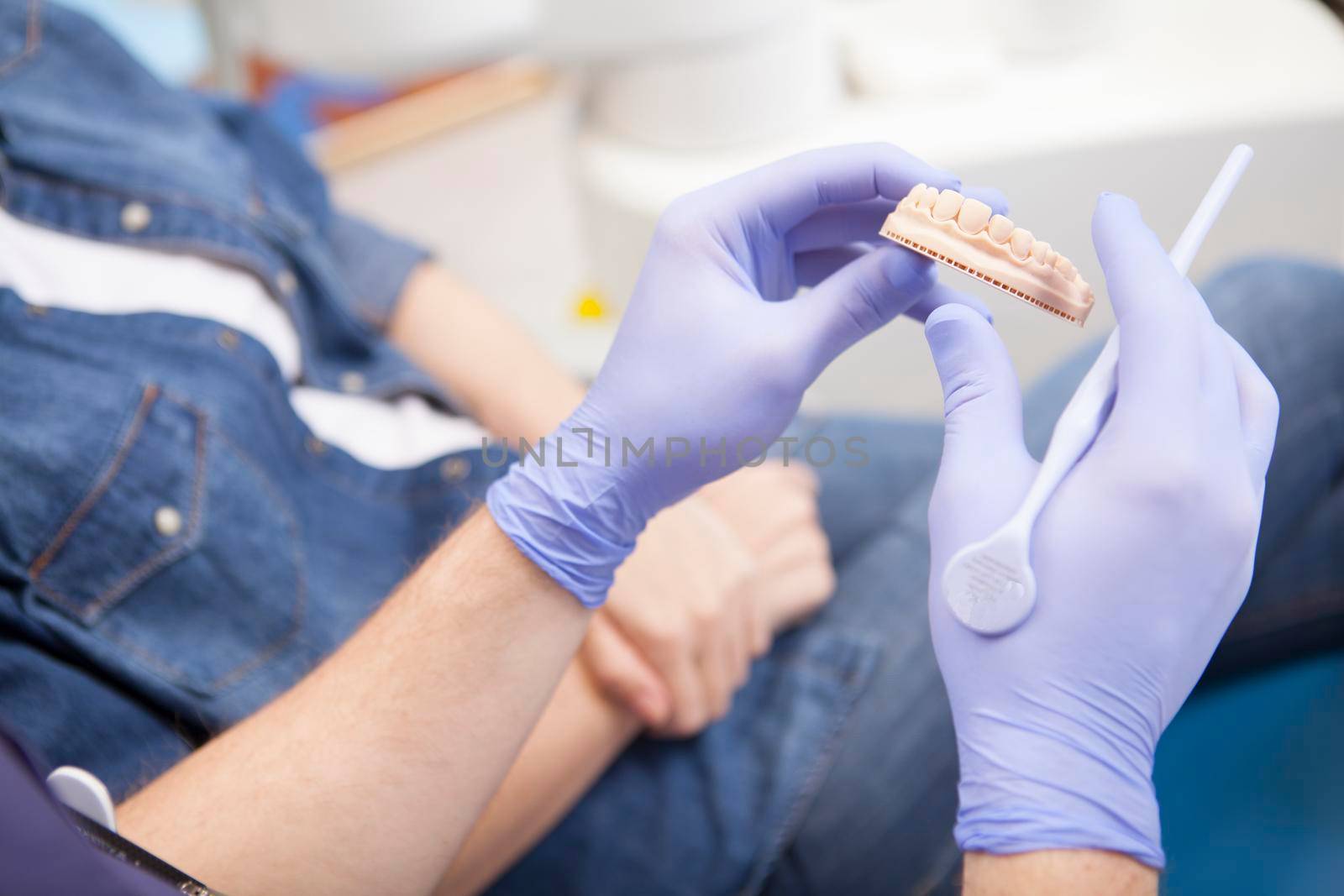 Dentist working with patient at his clinic by MAD_Production