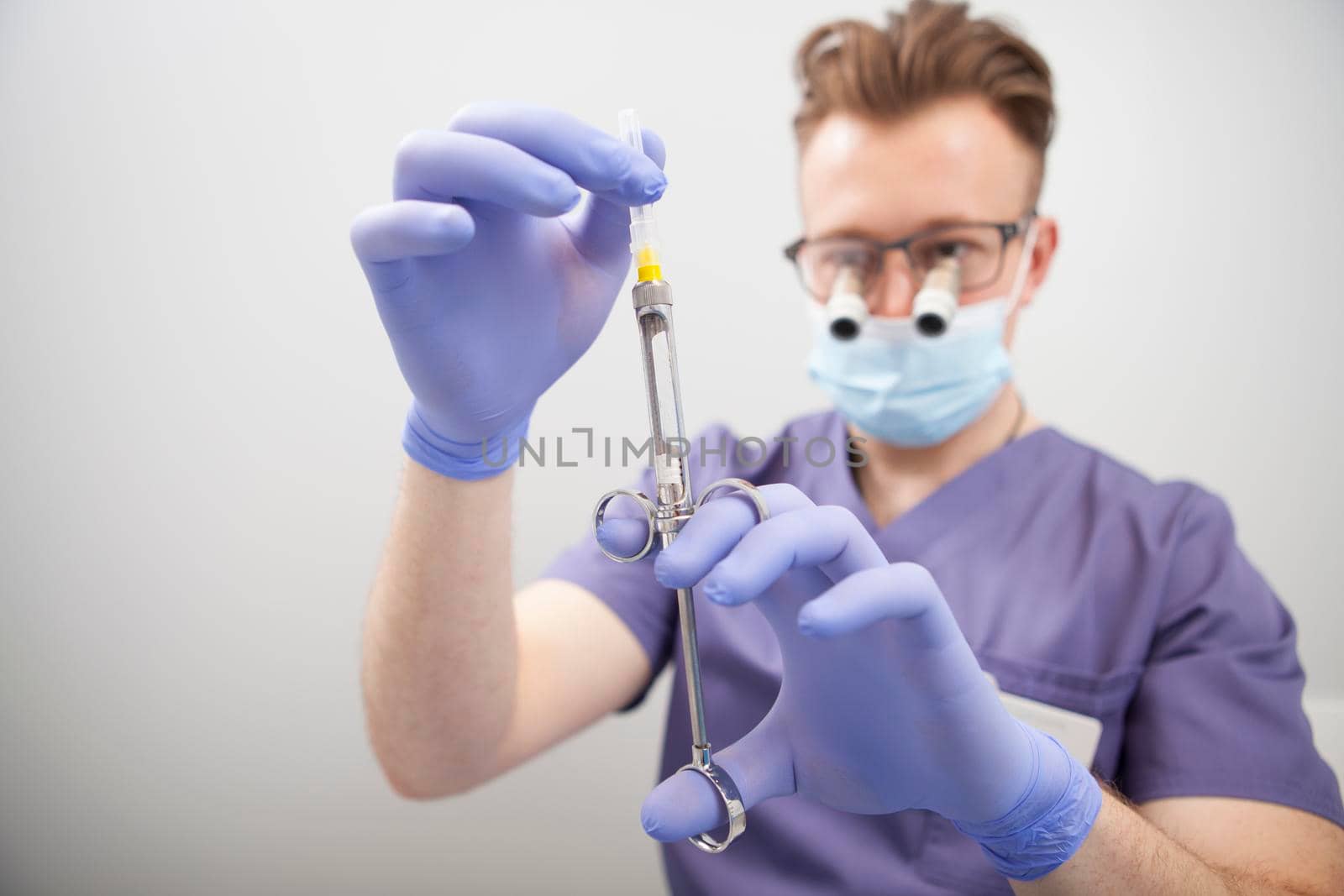 Doctor preparing syringe for injection by MAD_Production