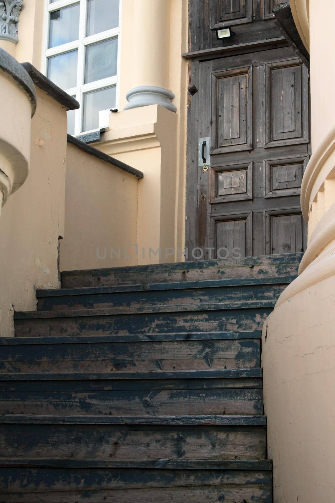 Entrance staircase of an old building made of light stone. Ancient city architecture.