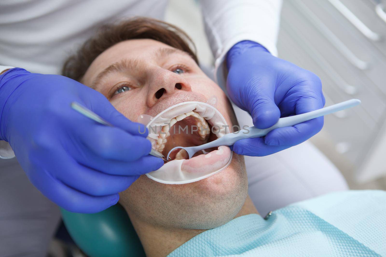 Close up of a man having his teeth examined by professional dentist