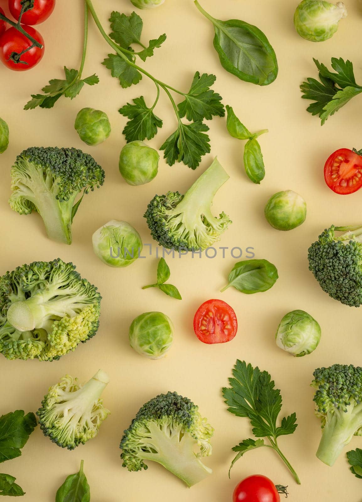 Vegetables food pattern made of broccoli, Brussels sprouts, cucumber, cut tomatoes, herbs, light pastel background. Minimal flat lay design about nutrition, healthy eating, diets, vitamins. Top view