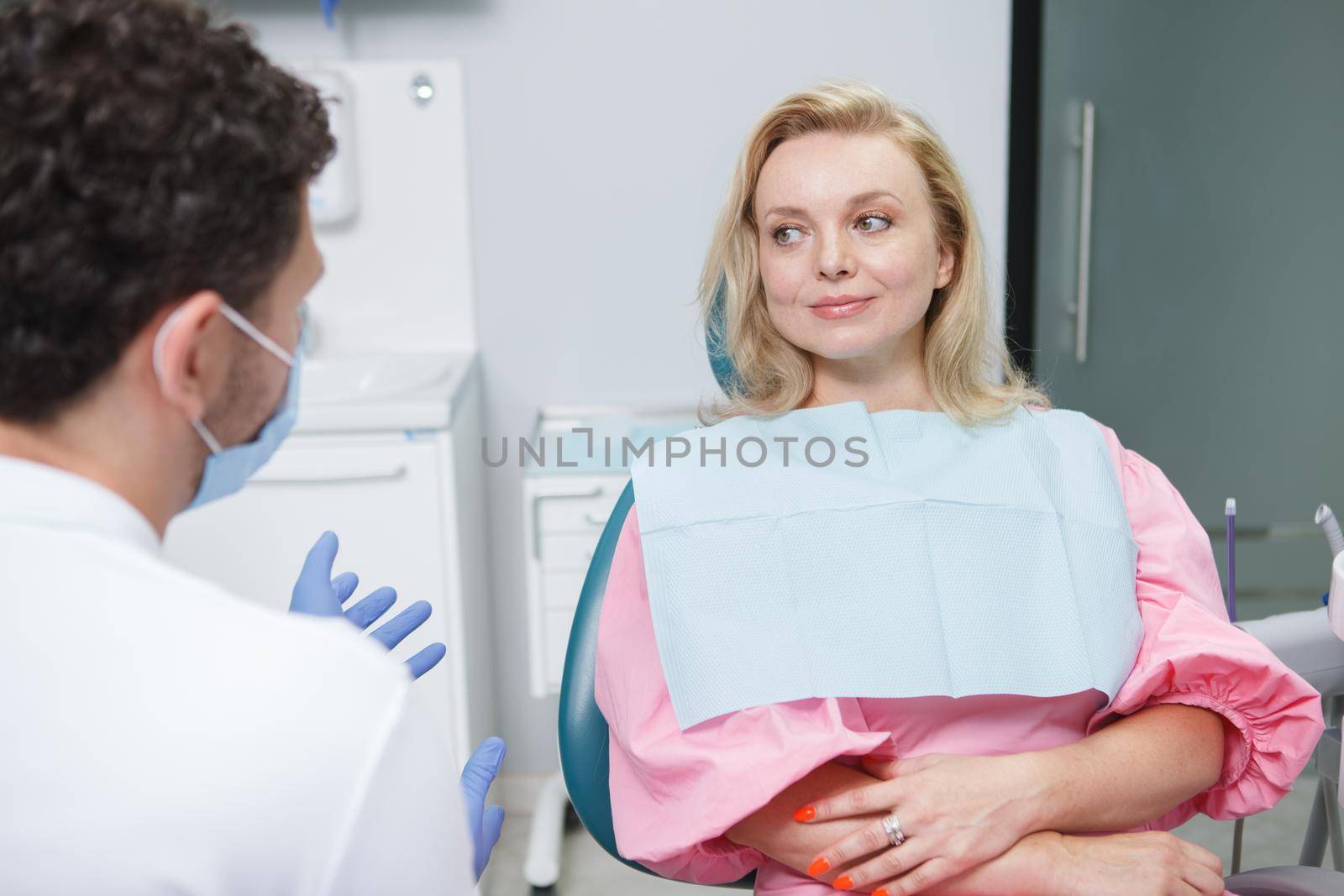 Cheerful female patient talking to her dentist