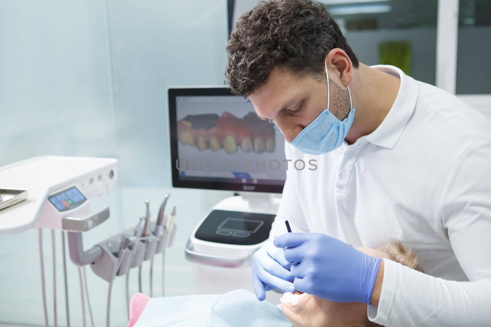 Professional dentist using dental scanner on teeth of a patient, copy space