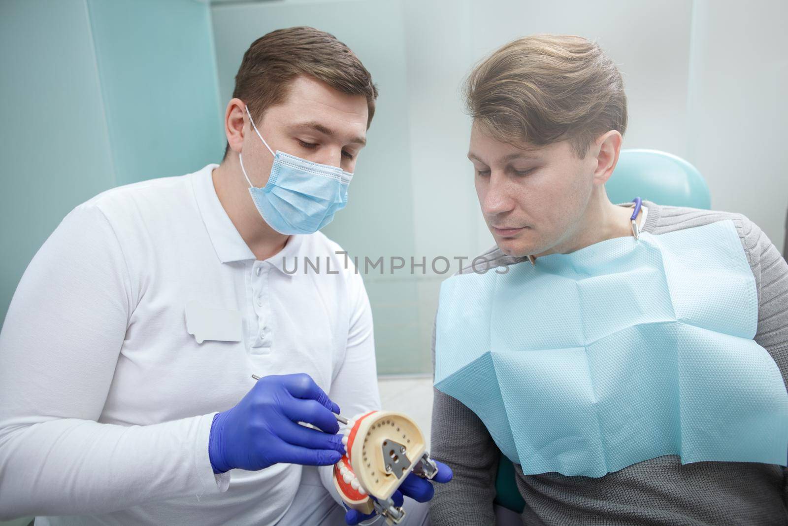 Mature man talking to his dentist on dental appointment at the clinic