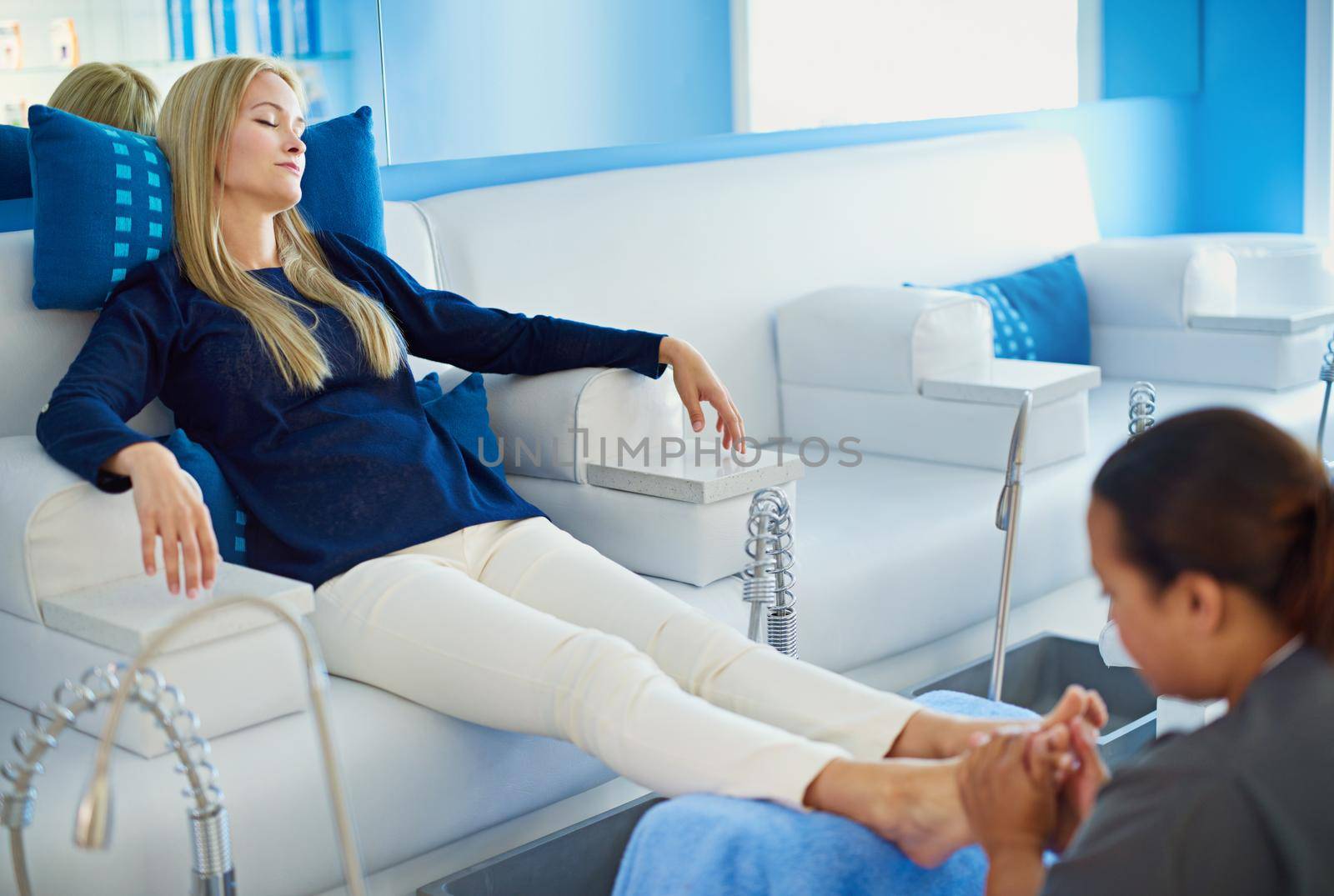 The best cure is a pedicure. a woman having her feet massaged at a beauty spa