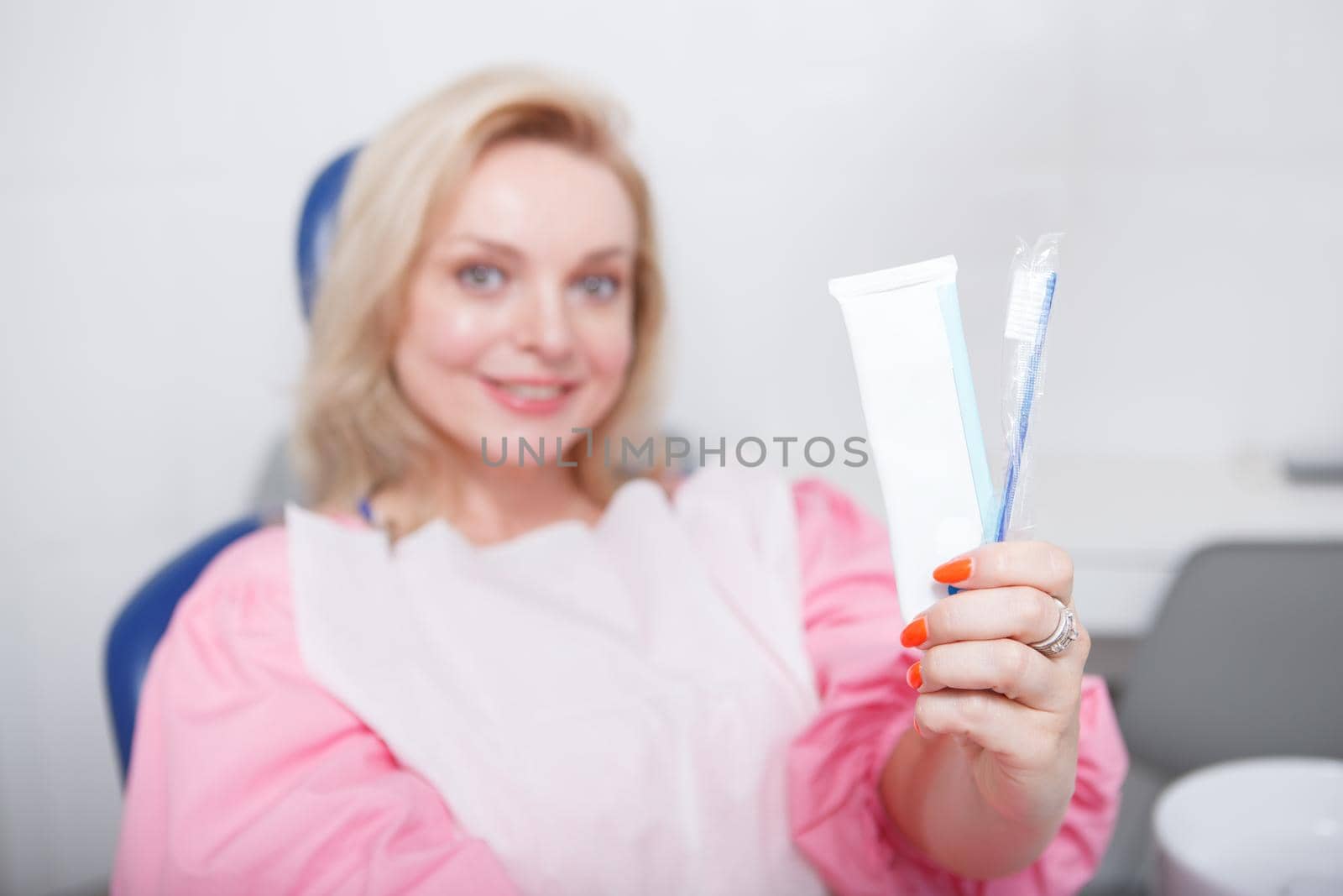 Selective focus on toothpaste and toothbrush cheerful woman is holding