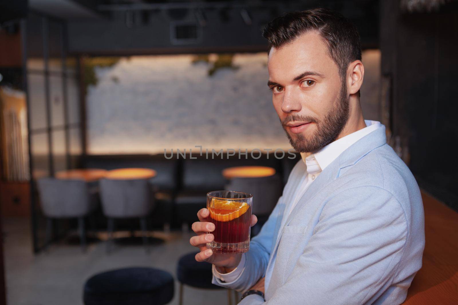 Handsome elegant man drinking whiskey at the bar by MAD_Production