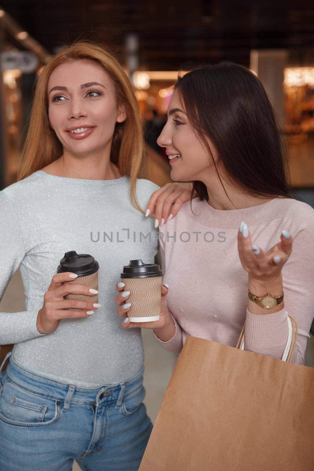 Two beautiful female friends laughing, enjoying shopping together