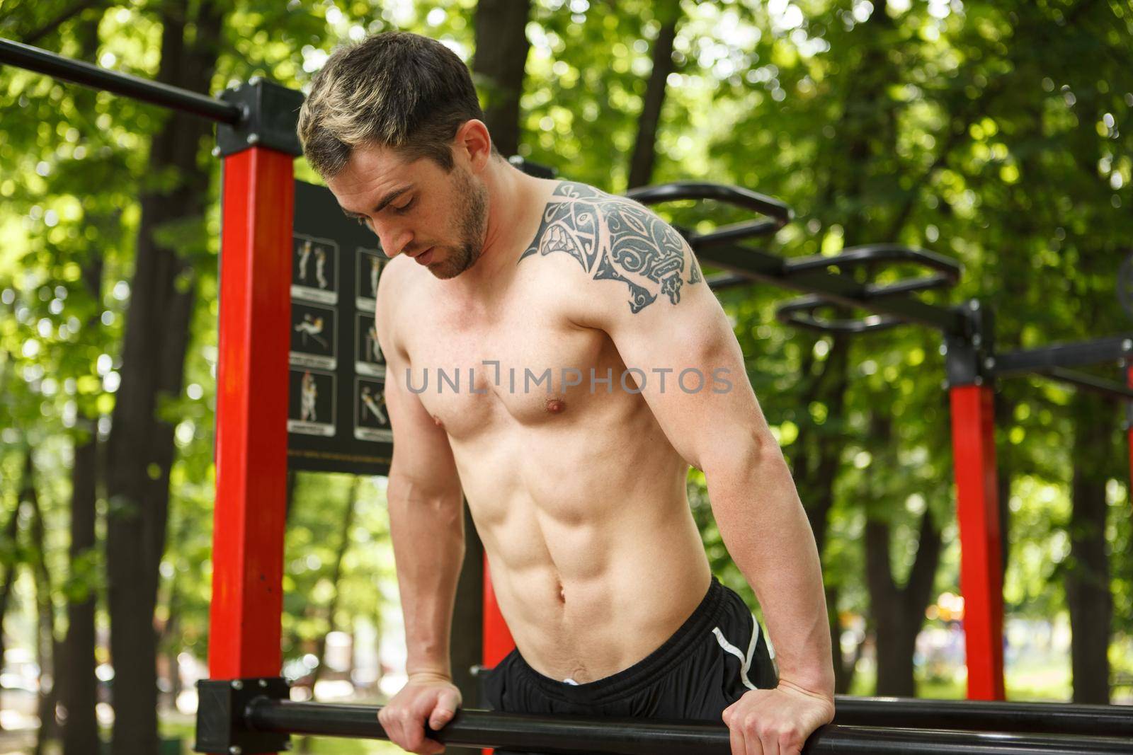 Shirtless male athlete with ripped torso exercising outdoors