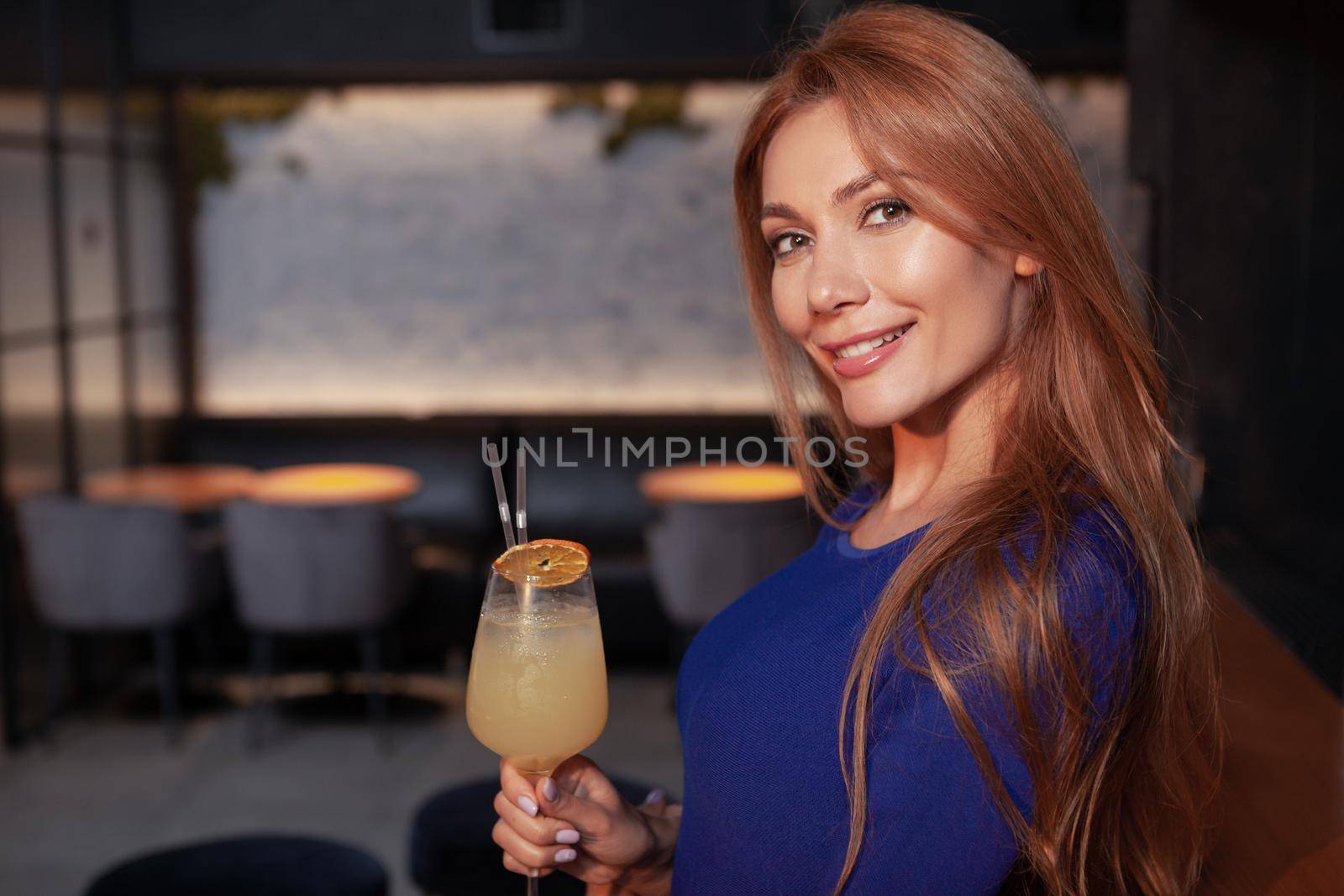 Gorgeous elegant woman enjoying cocktail at the bar by MAD_Production